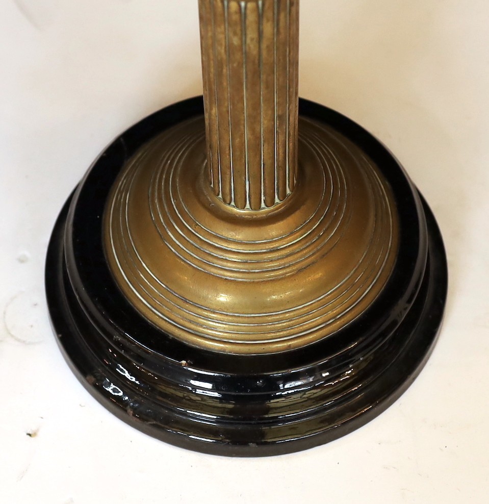 A late Victorian brass oil lamp with opaque pink glass reservoir, duplex mechanism, cranberry tinted etched glass shade and flue, height overall 65cm